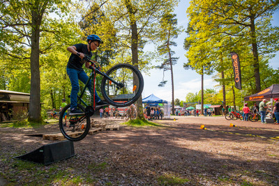 Junge springt mit Fahrrad über Rampe